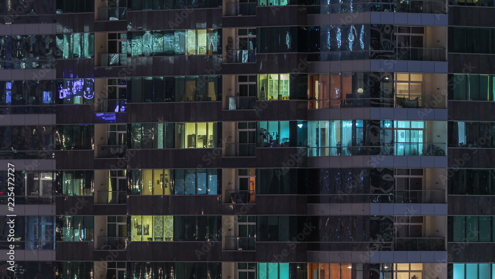 Windows of the multi-storey building of glass and steel lighting inside and moving people within timelapse - obrazy, fototapety, plakaty 
