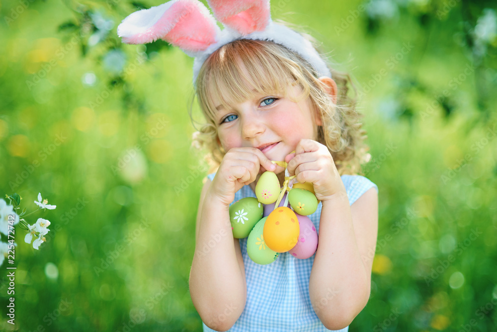 Cute funny girl with Easter eggs and bunny ears at garden. easter concept. Laughing child at Easter egg hunt Cute funny girl with Easter eggs and bunny ears at garden. easter concept. Laughing child at Easter egg hunt