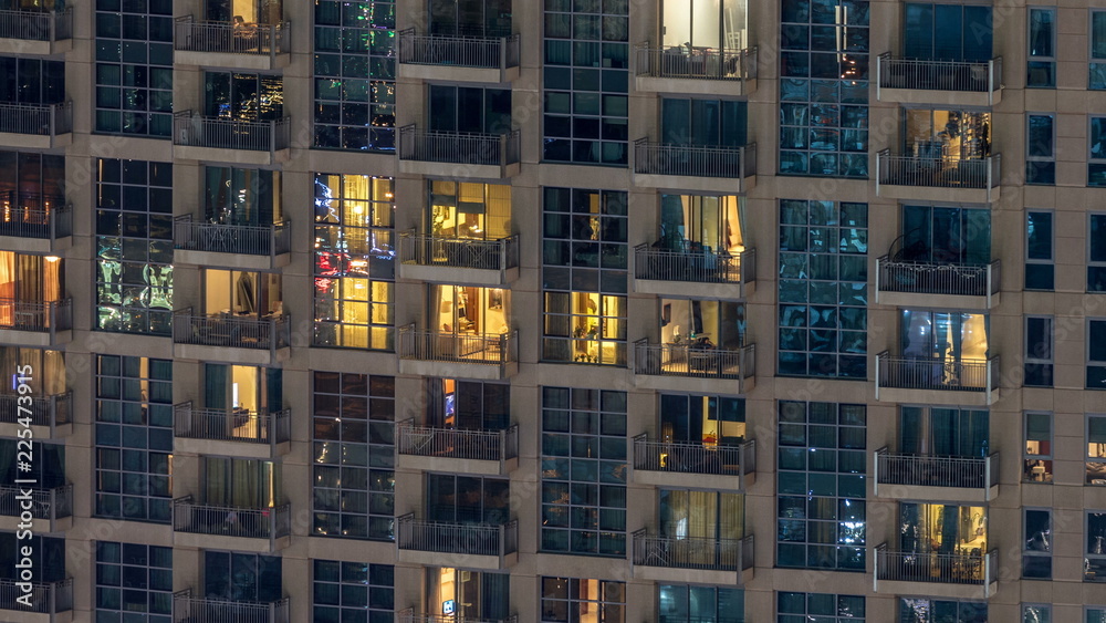 Windows of the multi-storey building of glass and steel lighting inside and moving people within timelapse Windows of the multi-storey building of glass and steel lighting inside and moving people within timelapse