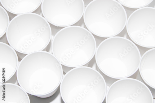 White paper cups for tea on a white background. Isolated objects. Gently hot. Disposable tableware. Dishes for a picnic.