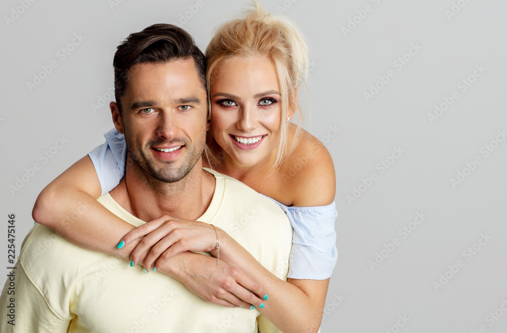 Young adult couple smiling and lookig at camera isolated on gray background Young adult couple smiling and lookig at camera isolated on gray background