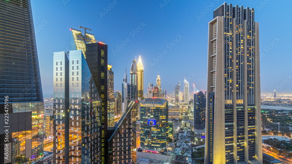 Obraz premium Skyline view of the buildings of Sheikh Zayed Road and DIFC day to night timelapse in Dubai, UAE.