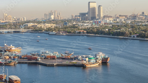 Dubai creek landscape timelapse with boats and ship in port and modern buildings in the background during sunset