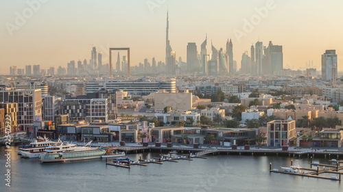 Dubai creek landscape timelapse with boats and ship near waterfront and modern buildings in the background during sunset © neiezhmakov