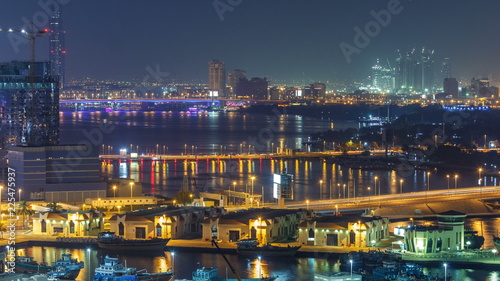 Dubai creek landscape night timelapse with boats and ship near waterfront