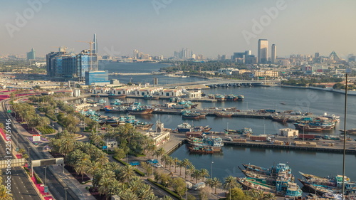 Dubai creek landscape timelapse with boats and ship in port and modern buildings in the background during sunset © neiezhmakov