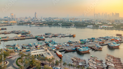 Dubai creek landscape timelapse with boats and ship in port and modern buildings in the background during sunset