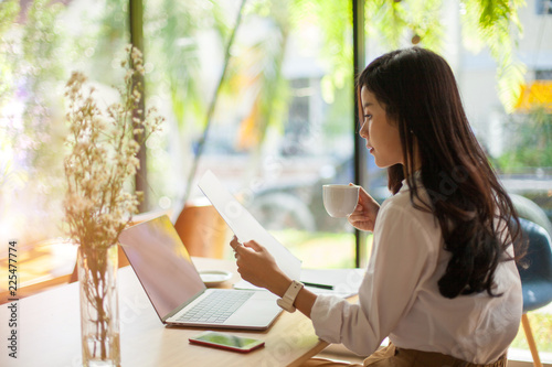 Portrait of Asian pretty young business woman sitting on workplace