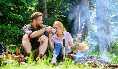 Food for hike and camping. Couple sit near bonfire eat snacks and drink. Couple in love camping forest hike. Hike snacks and beverages. Hike picnic. Couple take break to eat nature background