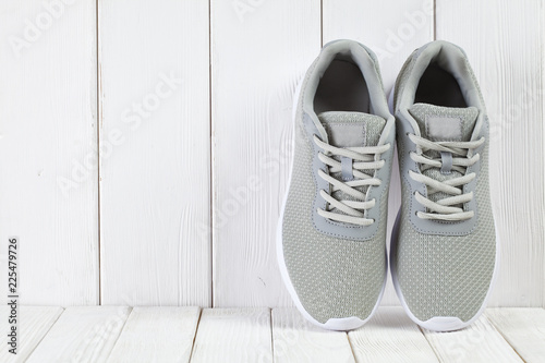 Sport symbols - gray sneakers on wooden wall background