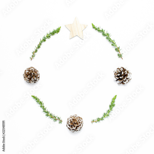 Christmas composition. Wreath of fir branches, cones, wooden toys on white background Flat lay top view copy space square. Christmas winter decoration, Nature New Year concept minimalist style