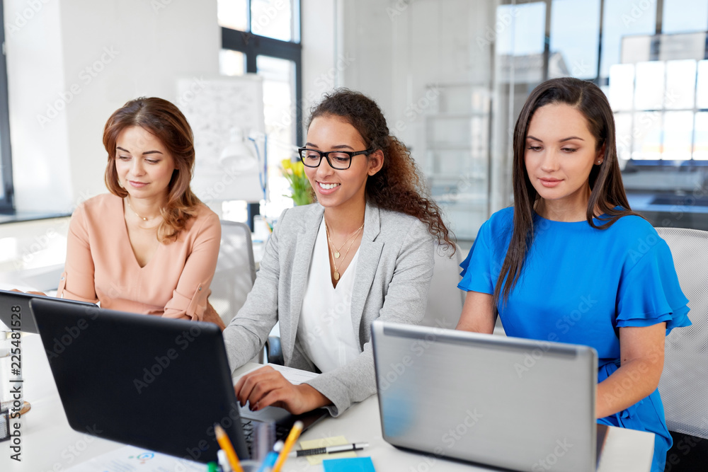 business, teamwork and people concept - female team or businesswomen with tablet pc and laptop computers working at office business, teamwork and people concept - female team or businesswomen with tablet pc and laptop computers working at office