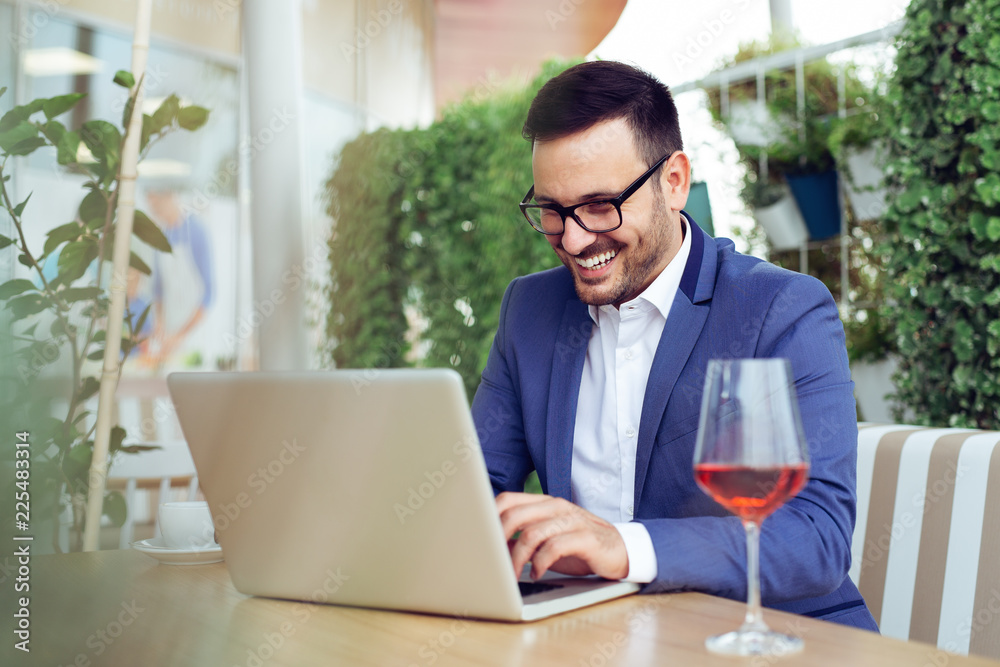 Handsome businessman using laptop at city cafe Handsome businessman using laptop at city cafe