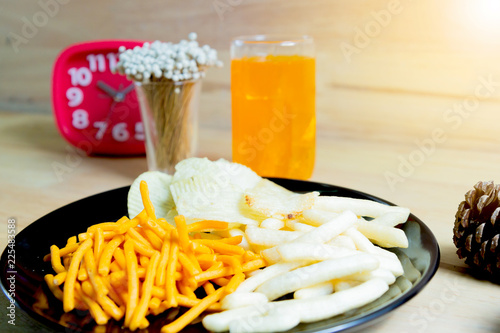 Relax time with juice and snacks on wooden table.