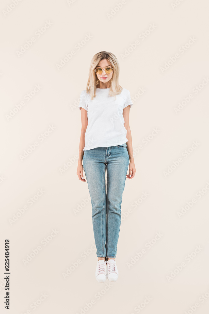 full length view of beautiful blonde girl in sunglasses smiling at camera isolated on beige full length view of beautiful blonde girl in sunglasses smiling at camera isolated on beige