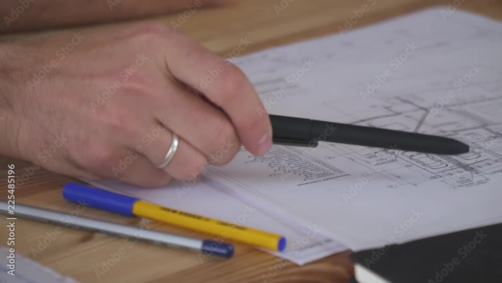 A man's hand with a ring holds the handle and shows the details of the drawing A man's hand with a ring holds the handle and shows the details of the drawing