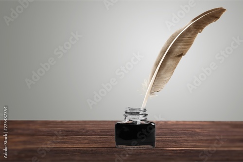 Feather quill pen and glass inkwell isolated