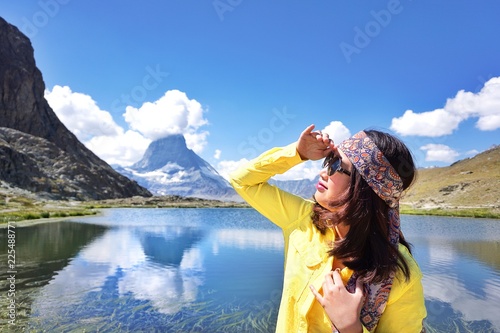 Happiness Asian beauty young girl traveller standing looking view near the alpine lake of Riffelhorn in front of mountain Matterhorn peak, Zermatt, Switzerland.Summer Vacation. photo