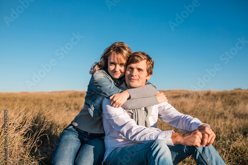 Happy young couple hugging and laughing outdoors.