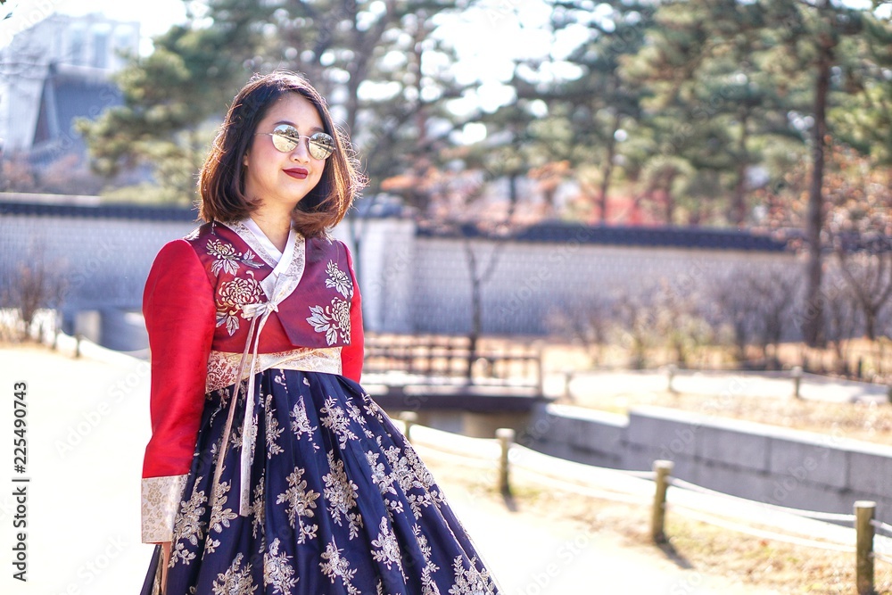 Fashion Portrait of young Asian Beauty girl in Hanbok traditional Korean clothes in autumn winter at the Gyeongbokgung Palace, Seoul, South Korea