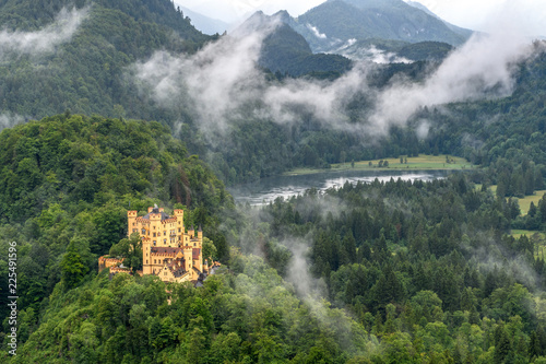 The Royal castle on the shore of a mountain lake. The forest-covered mountains against the stormy sky and fog. photo