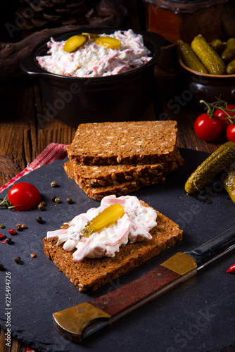 delicious spicy meat salad with cucumber on the black bread