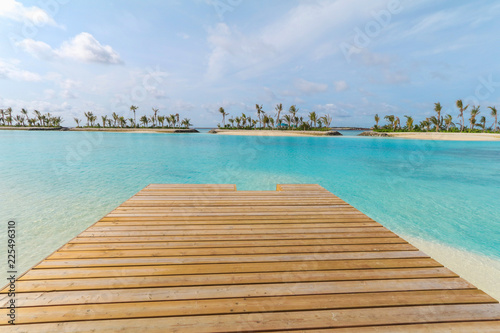 Amazing island in the Maldives ,Beautiful turquoise waters ,wooden bridge with  blue sky  background for holiday vacation . © Umarin