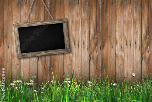 Blackboard on wood background with grass on the ground