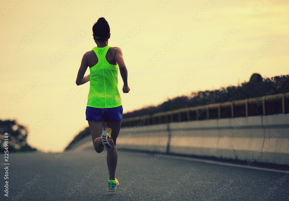 Fototapeta premium Female Runner athlete running on road. woman fitness jogging workout wellness concept