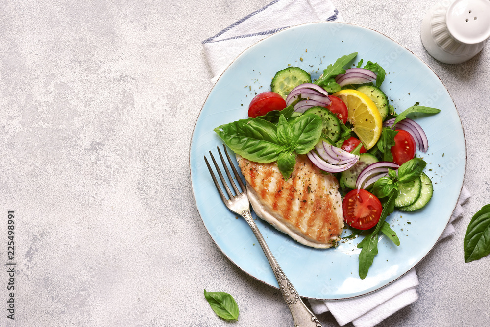 Grilled chicken breast with vegetable salad.Top view with copy space. Grilled chicken breast with vegetable salad.Top view with copy space.