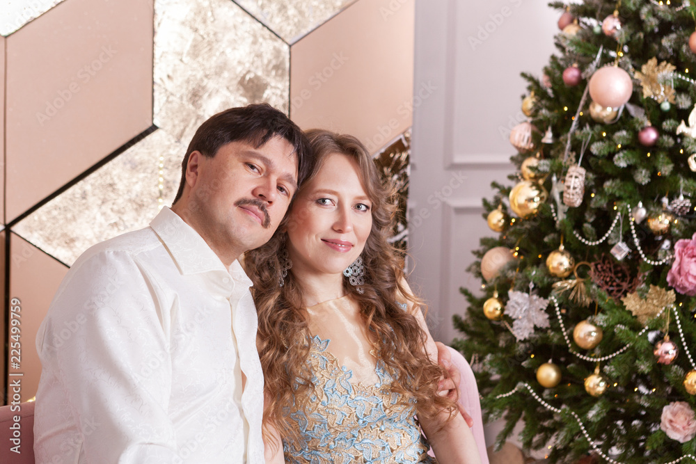 Portrait of beautiful happy family couple in Christmas decorations,