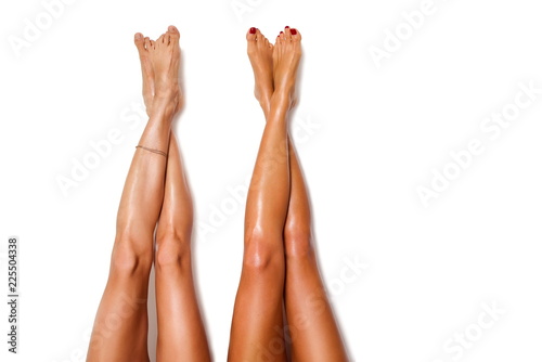 two beautiful pairs of smooth woman's legs after laser hair removal on the white background