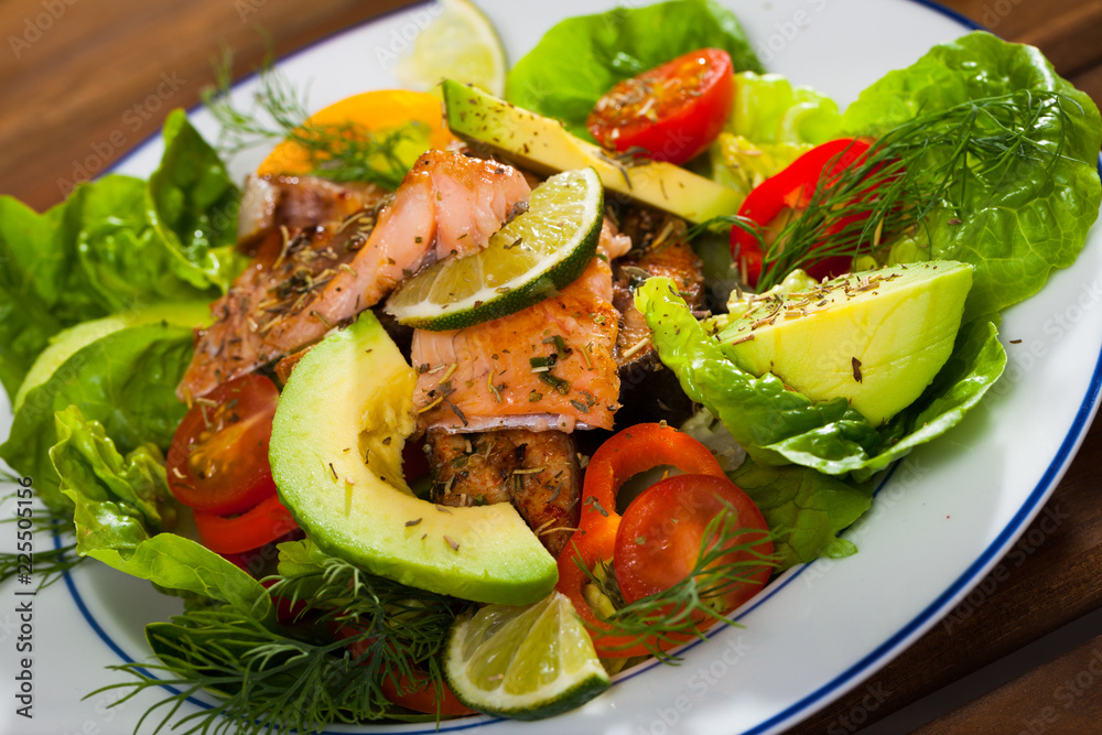Deliciously salad of  fried  trout with  avocado, greens and tomatoes