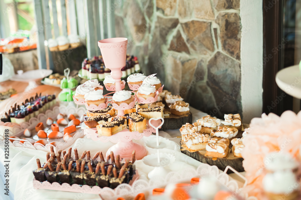 Naklejka premium Delicious sweets on wedding candy buffet with desserts, cupcakes