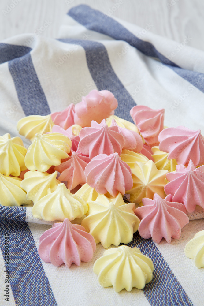 Mini meringues on striped napkin, side view. Closeup. Mini meringues on striped napkin, side view. Closeup.