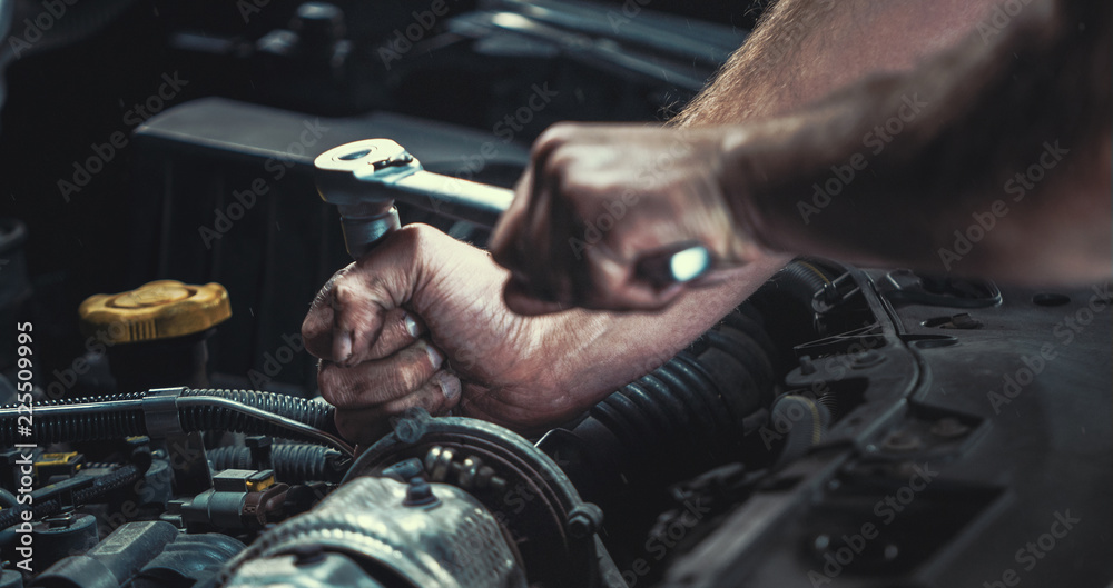 Auto mechanic working in garage. Repair service.