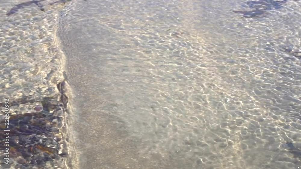 Water flowing in slow motion through ripple marks on a beach at low tide. Water flowing in slow motion through ripple marks on a beach at low tide.