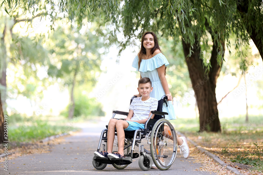 Teenage boy in wheelchair with his mother outdoors Teenage boy in wheelchair with his mother outdoors