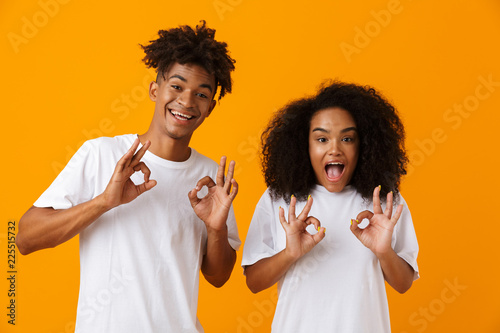 Young cute african couple posing isolated over yellow background showing okay gesture.