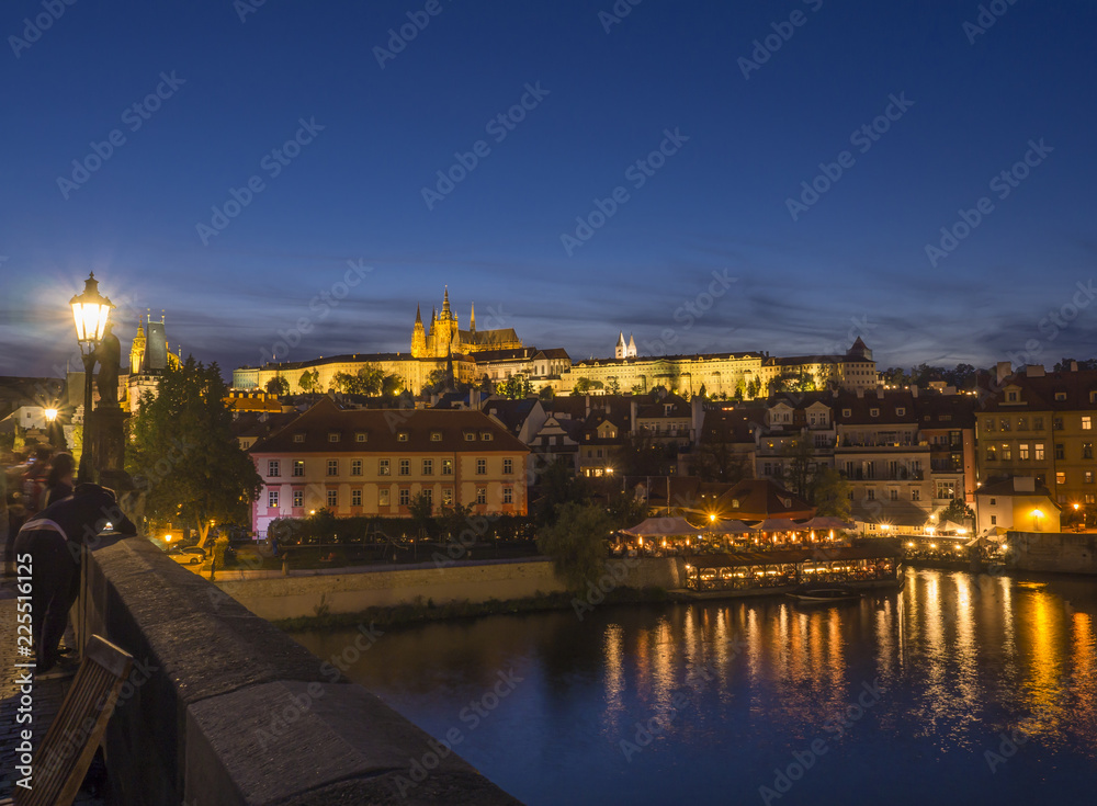 Night view from Charles bridge of illuminated St. Vitus Cathedral gothic churche and Prague Castle panorama with hradcany, dark blue sky