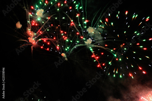 Beautiful fireworks in the night sky. A bouquet of red and green lights. Celebrating Christmas and New Year