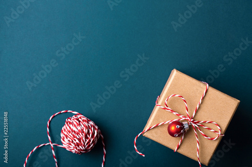 Gift box wrapped in kraft paper and tied with candy cane Christmas rope on da...