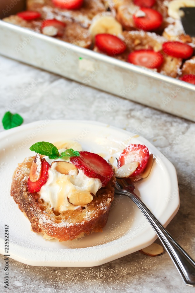 Breakfast baked french Toast served in a plate topped with berries nuts and banana, top view Breakfast baked french Toast served in a plate topped with berries nuts and banana, top view