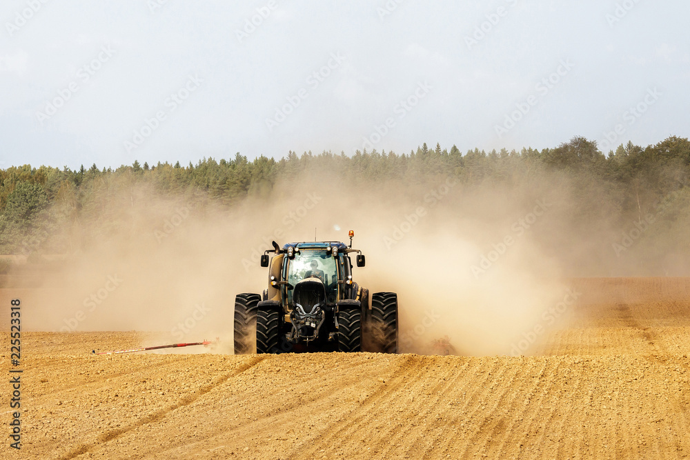 Fototapeta premium tractor handles land, very put