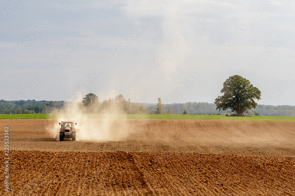 Fototapeta premium tractor handles land, very put