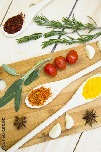 Cooking Hot Spicy Food Concept. Dry spices and herbs in wooden spoon on a cutting board