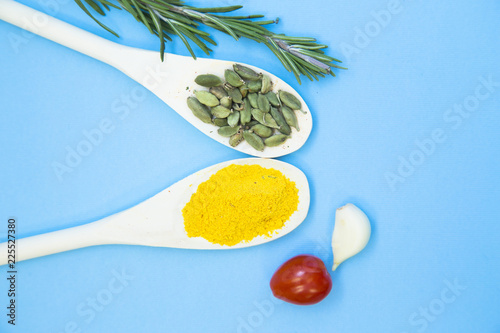 Cooking Hot Spicy Food Concept. Dry spices and herbs in wooden spoons, light blue background photo