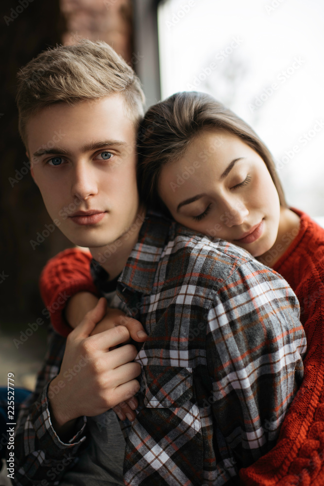 Beautiful lovely couple hugging in cozy loft house. Portrait of young  family posing for camera. Harmony. Relationship. Balance. Boyfriend and  girlfriend sitting near window. Stock Photo | Adobe Stock