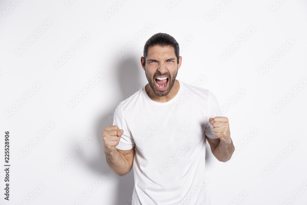 Attractive  young man sreaming on white background with natural shadow.