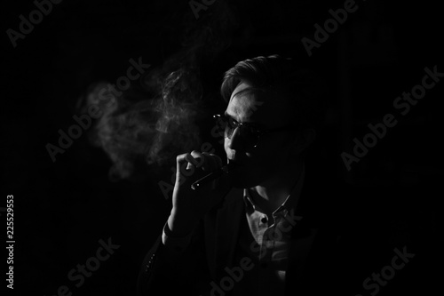 portrait of a man with glasses smoking a cigar